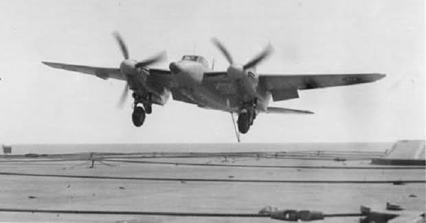 Bringing it aboard, a RN pilot drags his Sea Mosquito onto the arrester cables with hook and flaps down, and the Merlin 25s about to be cut.