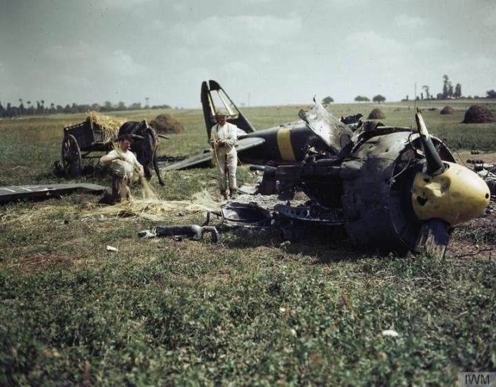 Two French farmers work around the wreckage of a Luftwaffe Ju-88 in Normandy, 1944. (IWM TR 2107)