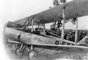 Bert Hinkler runs the engine of his Avian G-EBOV for a crowd of onlookers, somewhere in Queensland after his 1928 flight from England. (State Lib. of Queensland)